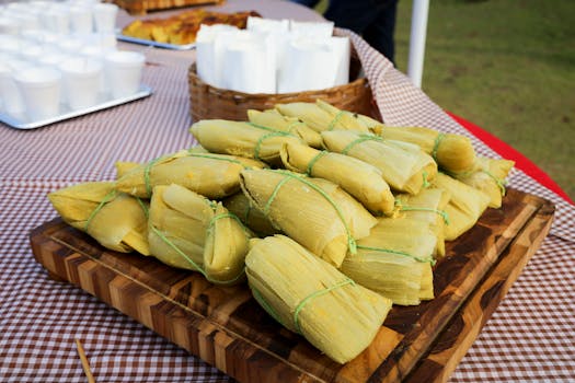 Close-up of corn husk-wrapped tamales on a wooden tray, perfect for food bloggers.