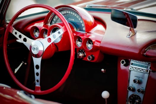 Vintage Chevrolet Corvette dashboard with red interior and classic steering wheel design.