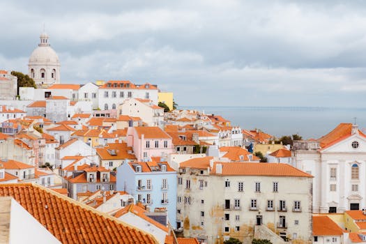Lisbon's Alfama district with red rooftops and the sea.