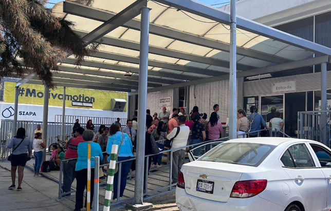 A long line of people waiting at a SIAPA office in Mexico.